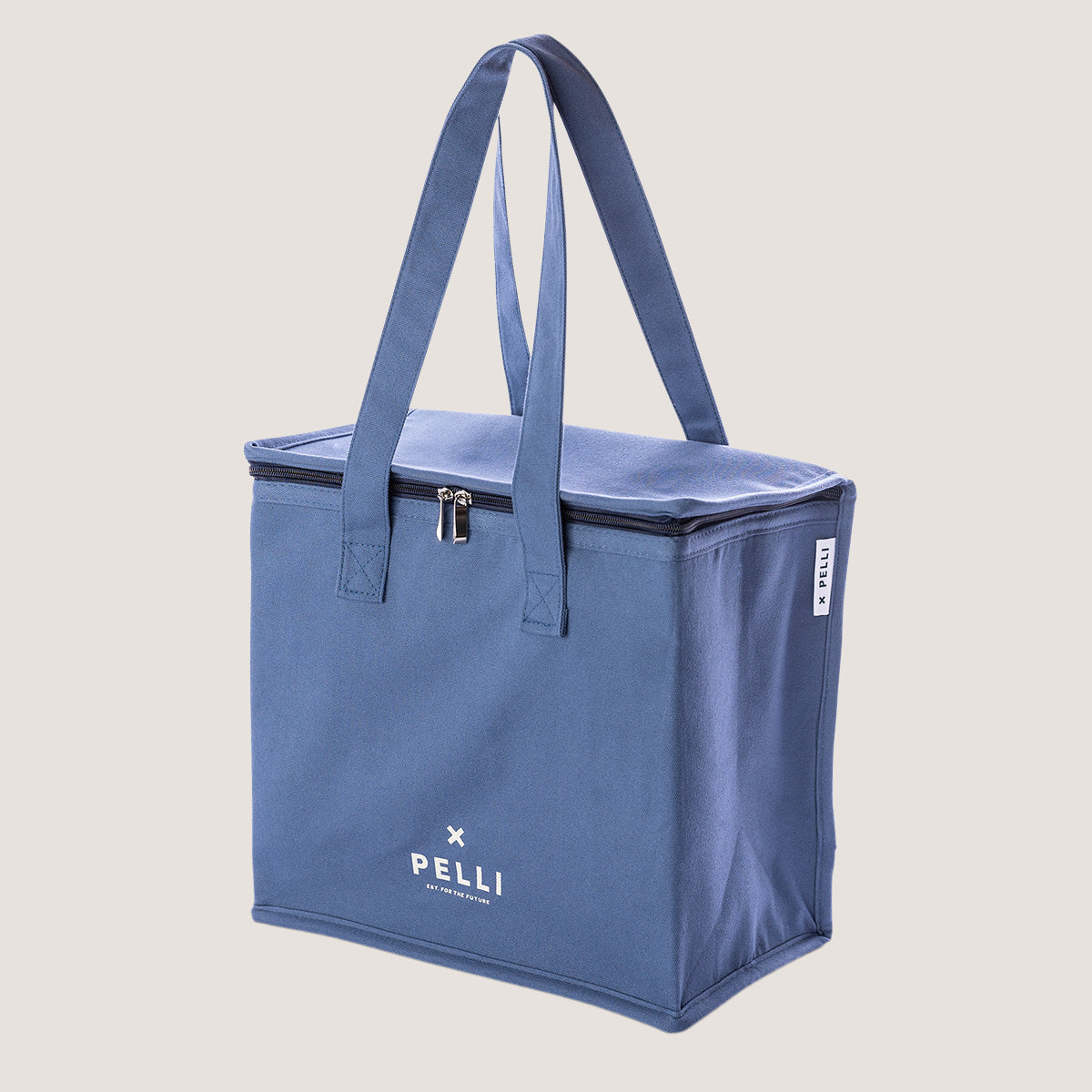 A canvas medium cooler bag in ocean blue with straps held up